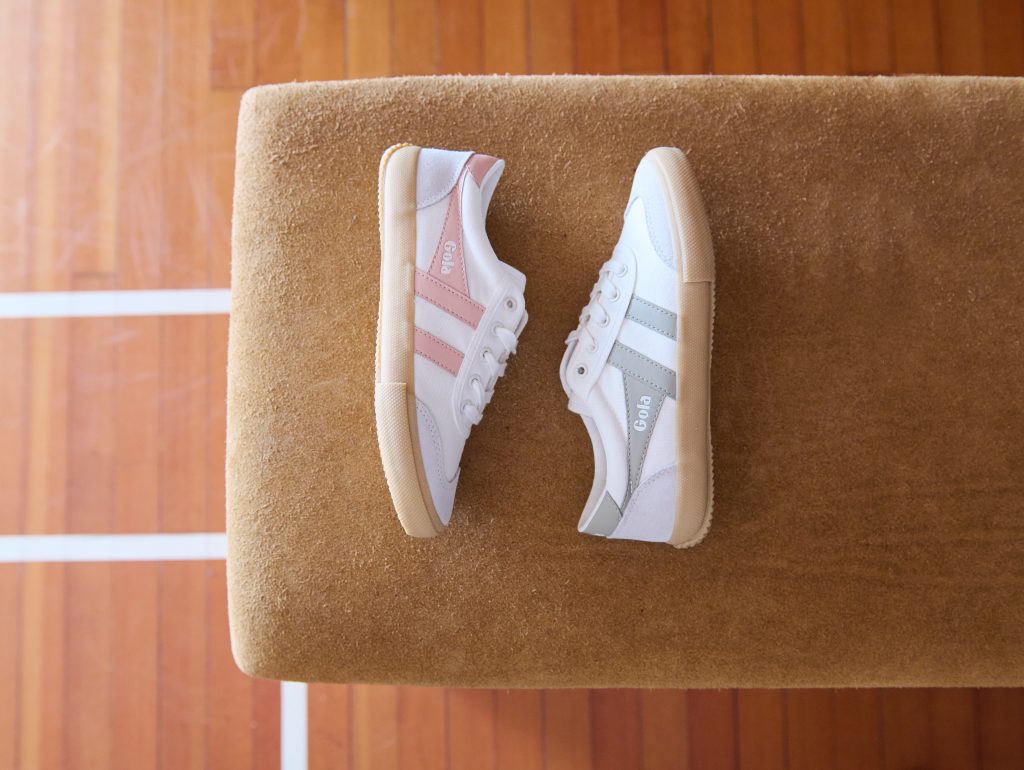 An aerial shot of women's Badminton plimsolls on a jumping horse in the gym