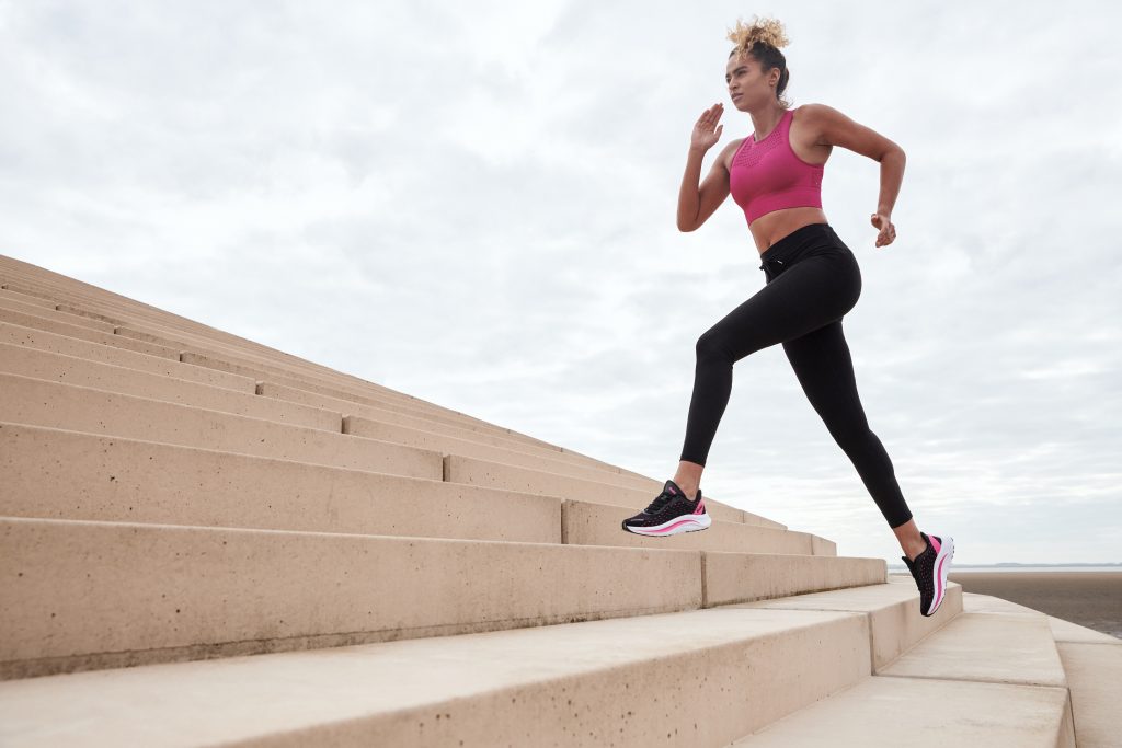 Woman running up steps outside wearing Gola trainers