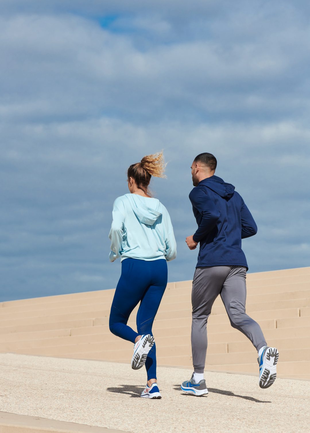 Man and woman running in the sun in Gola Perforamnce trainers