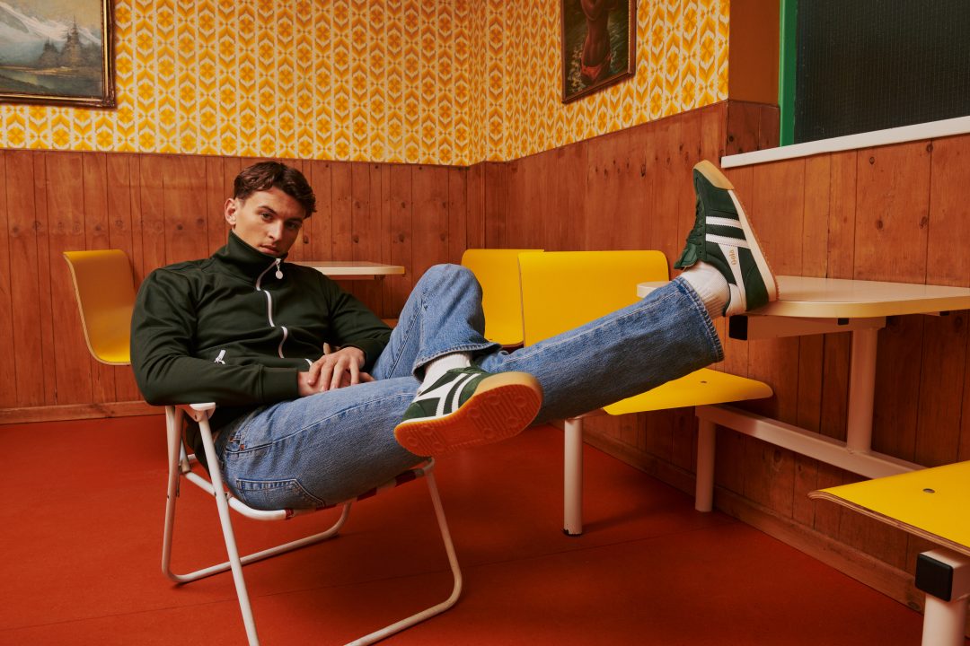 A close up of a man dressed in terracewear wearing a pair of Harrier trainers
