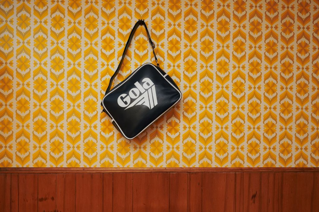 Redford bag hanging on a wall against retro wall paper